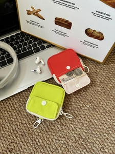 Close-up of portable square coin purses in red and neon green with hanging hooks