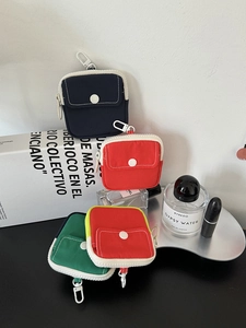 Detail of colorful canvas mini pouches with snap pockets, zippers and hanging hooks