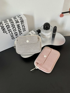 Detailed view of mini fabric organizer bags with zipper and metal button front pocket