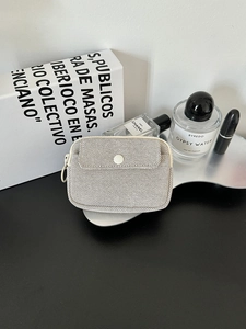 Detail of beige mesh organizer pouch with snap pocket for earphones and lipstick