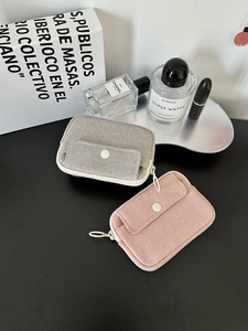 Macro detail of canvas organizer pouches with button flap and large ring zipper in pink and grey
