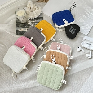 Close-up of quilted mini earphone pouches with plastic hooks in seven pastel colors