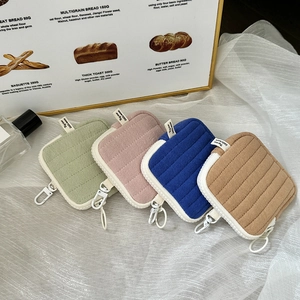 Set of four quilted mini zipper pouches in pastel green, pink, royal blue, and tan brown