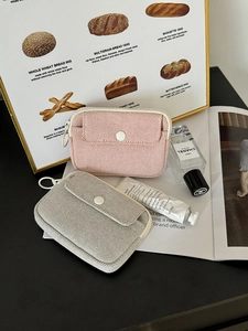 Detailed close-up of woven mini organizers with zipper and front snap button pocket