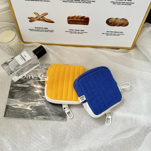 Detailed view of yellow and blue quilted cotton coin purses with D-ring hooks