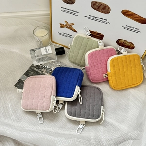 Detailed view of colorful quilted mini storage pouches with hooks on white mesh background