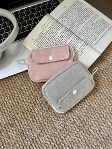 Close-up of woven fabric tech pouches with zipper and button pocket for accessories