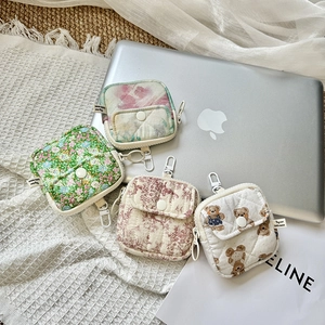 Detail of quilted mini storage pouches with various floral patterns and metal hooks