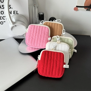 Detailed view of quilted mini headphone cases in various colors with metallic carabiners