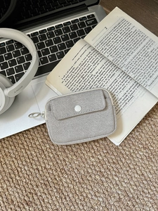 Close-up of light grey mesh mini pouch for AirPods featuring a secure snap button and metal hook