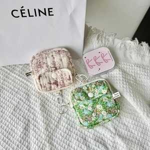 Detailed shot of quilted mini storage pouches for earbuds in red and green floral designs