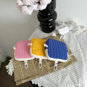 Close-up of quilted mini pouch with carabiner hook showing zipper detail and texture