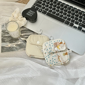 Quilted mini earphone pouches with carabiner hooks shown in a desktop lifestyle setting