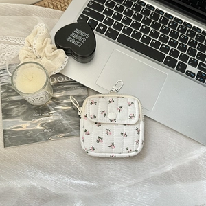 Detail of white quilted mini floral coin purse with a metal carabiner and snap pocket