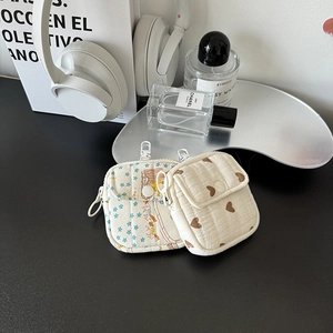 Quilted mini earphone pouches with star and heart patterns on a stylish silver tray