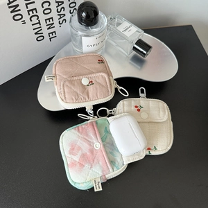 Detailed view of quilted fabric earphone pouches with cherry prints and metal hooks