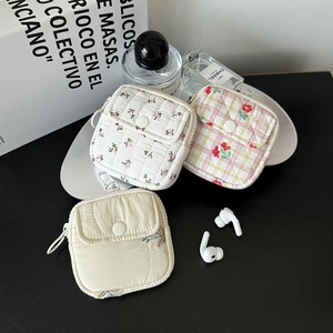 Close-up of quilted floral earbud pouches with snap buttons and secure swivel hooks
