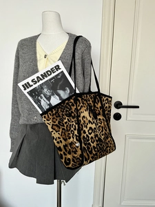 Large leopard print canvas tote bag with black handles displayed on a shoulder mannequin