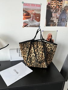 Detail of leopard print canvas tote bag featuring reinforced black handles and large capacity