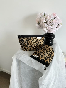 Dettaglio di mini pochette trucco leopardate in tela con cerniere in metallo a forma di orso
