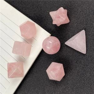 Macro view of rose quartz crystal geometry set showing natural textures and translucent pink hues