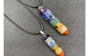 Detail view of hexagonal rainbow crystal pendants with multi-color stones and woven cord