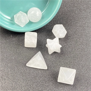 Macro detail of seven white crystal sacred geometry shapes on a textured gray background