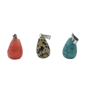 Three teardrop natural stone pendants in pink, dalmatian, and turquoise with silver bails
