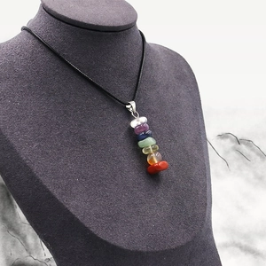 Natural seven chakra crystal stone pendant necklace with black woven cord on model