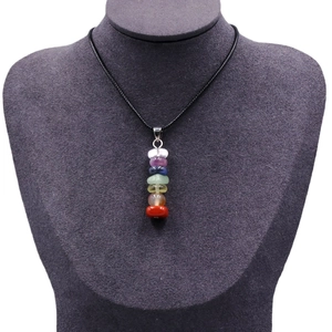 Natural seven chakra raw stone necklace with multi-colored crystals on a black cord