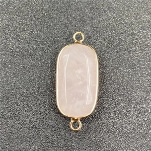 Detail of faceted rose quartz connector with gold rim and double hooks for DIY jewelry