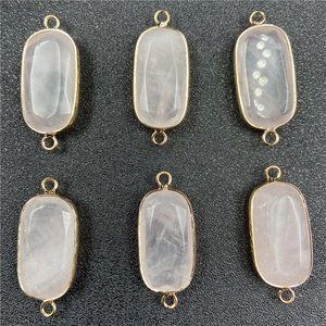 Detail of six rose quartz oval pendants with gold plated edges and double loops