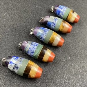 Detail of seven chakra crystal stones pendants with metallic clasps on black background