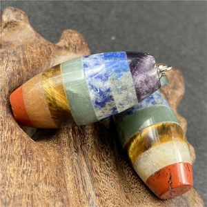 Macro detail of natural chakra barrel stone pendant with colorful mineral layers