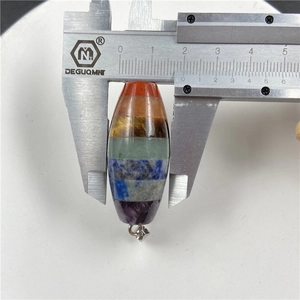 Macro shot measuring width of seven chakra healing stone pendant with a digital caliper