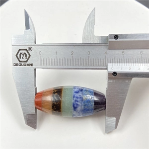 Macro shot of a 42mm colorful chakra stone barrel pendant measured by a caliper