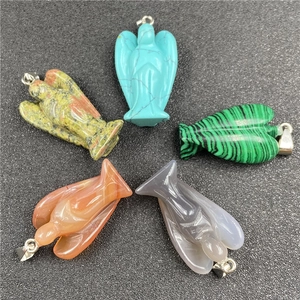Macro shot of natural crystal angel pendants in turquoise and various healing stones