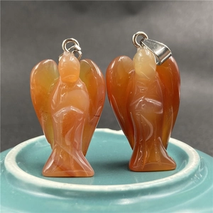 Macro detail of red agate angel pendants with natural stone patterns and silver loops