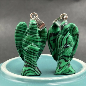 Detailed view of polished green malachite angel pendants with silver-tone metal bails