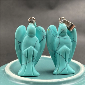 Close-up of angel crystal pendants with turquoise texture and silver clasps
