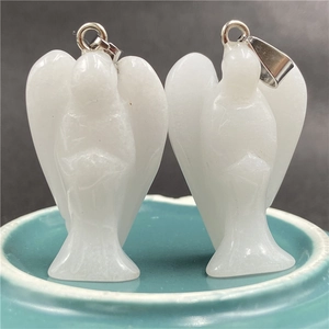 Close-up of two white natural crystal angel pendants with elegant silver metal bails