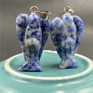 Detail of two angel-shaped natural blue sodalite pendants with silver metal clasps