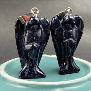 Macro shot of two blue sandstone angel pendants with sparkling metallic bail accents