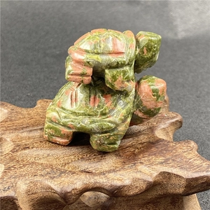 Close-up of a hand-carved Unakite turtle figurine featuring detailed natural stone textures