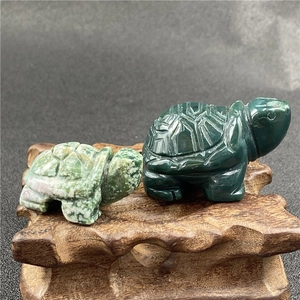 Detailed view of hand-carved gemstone turtles featuring intricate shell textures on wood
