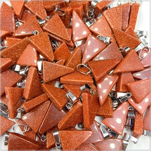 Close-up of triangular goldstone pendants with glittering finish and silver bails