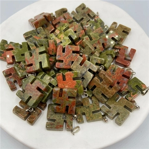 Polished natural stone swastika pendants in green and red textures with silver clasp
