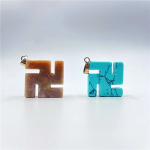 Macro detail of swastika charms in orange agate and turquoise with silver clasps
