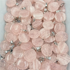 Vue détaillée de pendentifs en quartz rose naturel sculptés en forme de fleurs délicates
