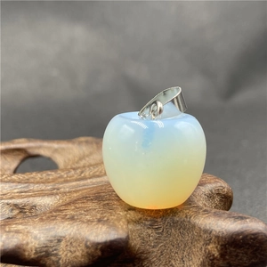 Makroansicht des Opal-Apfelanhängers auf Holzbasis, elegantes Weihnachtsgeschenk-Detail